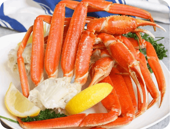 A plate of crab legs and lemon wedges.
