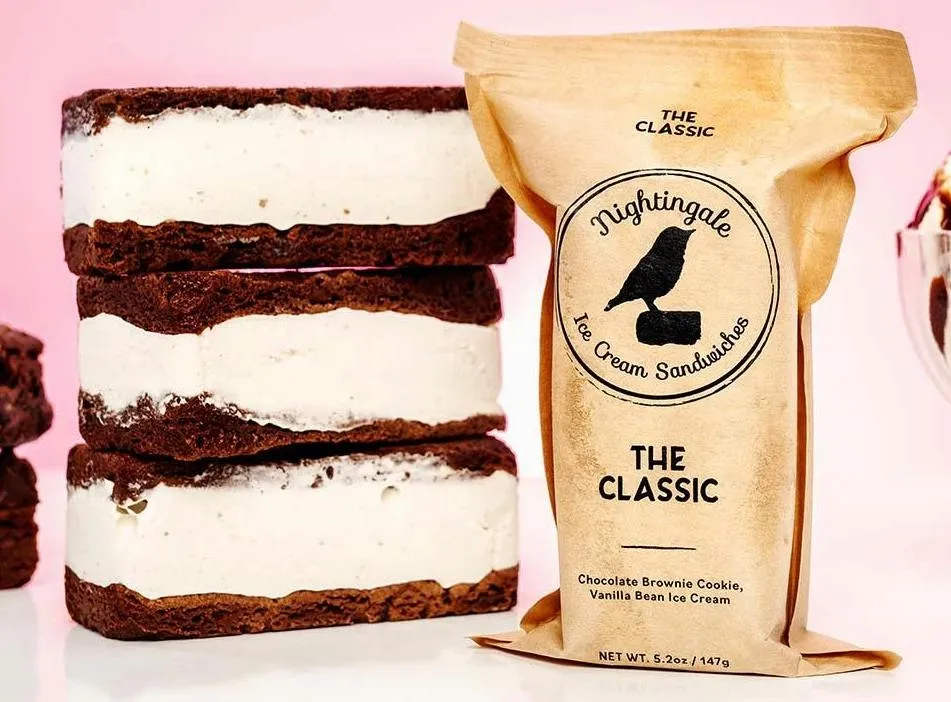 A bag of chocolate ice cream sandwich next to three pieces of cake.